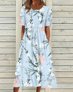 Light blue floral midi dress with short sleeves and gathered waist, knotted front detail