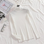White ribbed knit turtleneck sweater with long sleeves, laid flat