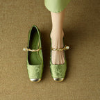 Green Mary Jane flat shoes with twisted strap, pearl button detail, and low block heel