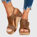 Brown suede wedge sandals with open toe, ankle strap, and stud trim on the sides.