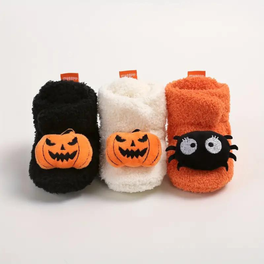 Halloween cartoon slippers in black, white, and orange with jack-o'-lantern face applique