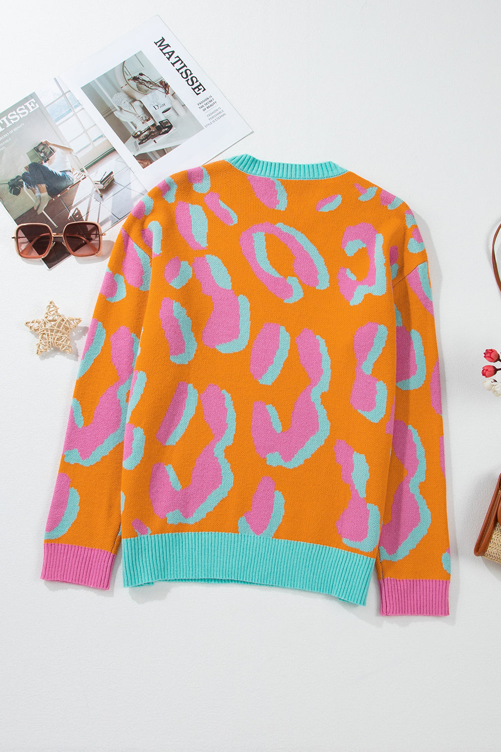 Women’s back view sweater with orange, pink, and teal leopard-style knit; ribbed collar and hem.