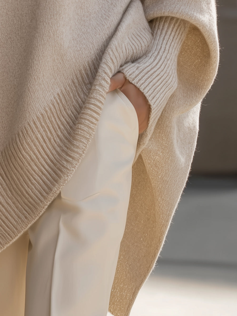 Ribbed knit cuff and hem detail on oversized poncho sweater, light beige