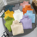 Folded turtleneck sweaters in mint, gray, peach, orange, blue, lavender, and white.