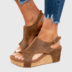 Brown wedge sandals with side cutouts, ankle strap, and stud accents on the wedge.