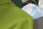 Lime green turtleneck knit texture close-up on the shoulder and sleeve area.
