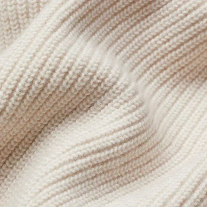 Women’s cream knit cardigan fabric close-up with textured ribbed pattern