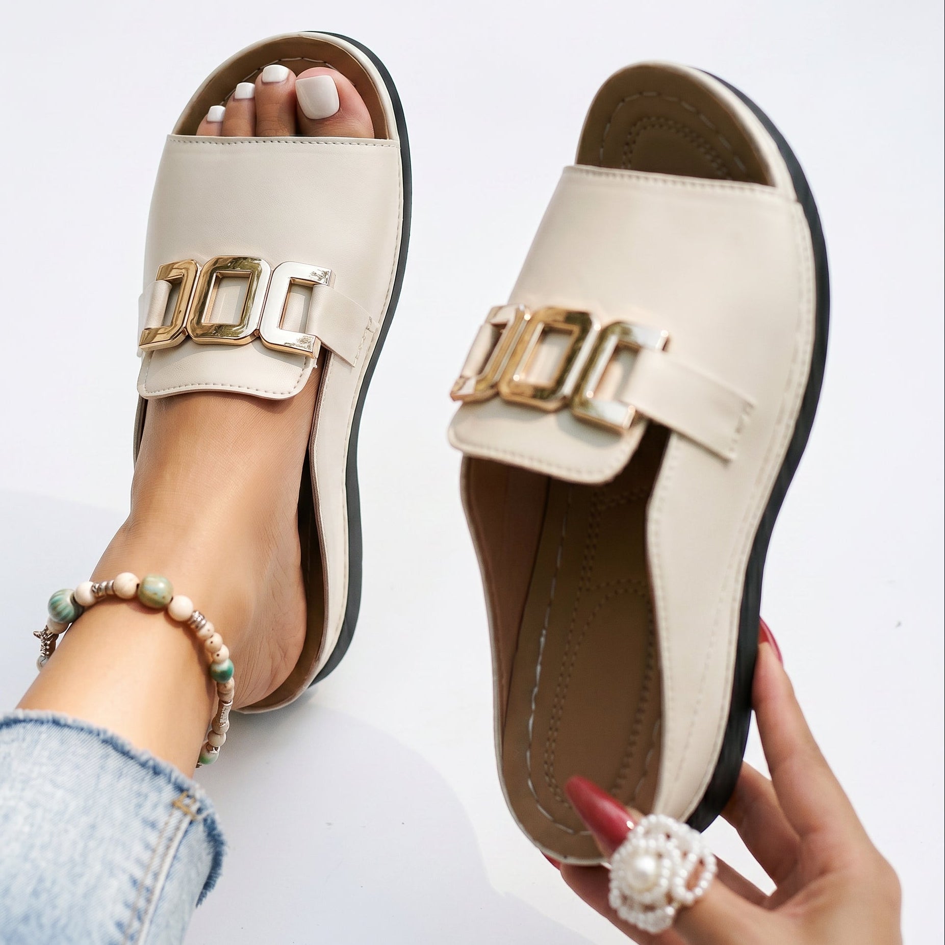 Cream open-toe sandals with gold-tone square buckle and stitched detailing