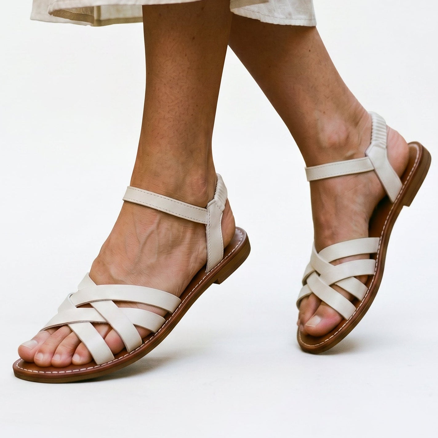 White strappy flat sandals with crisscross straps and open toe