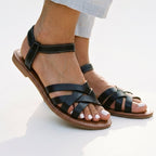Black flat strappy sandals with ankle strap and open toe