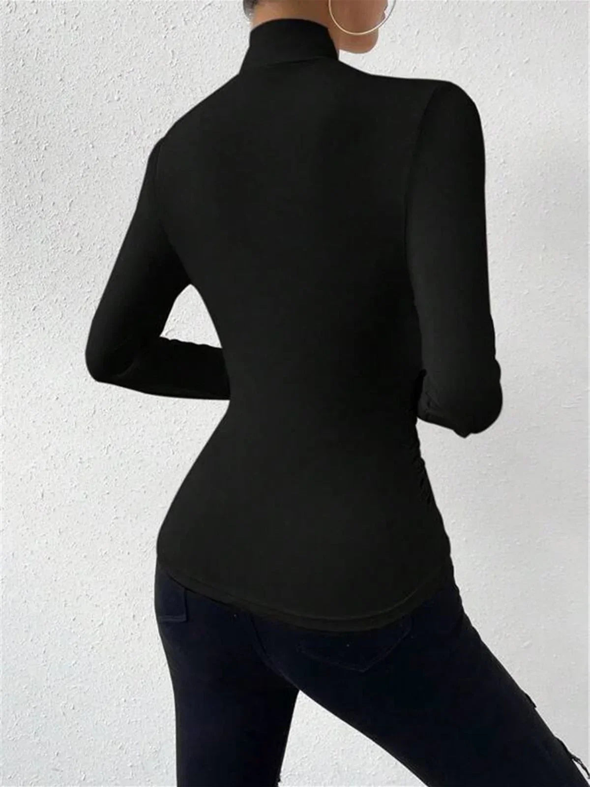 Black wrap turtleneck top with long sleeves and high collar, back view