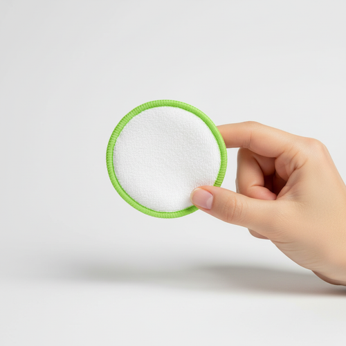 Green reusable bamboo cleansing pad held in hand