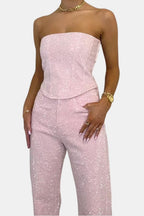 Pink strapless glitter jumpsuit close-up: corset bodice and high-rise waistband