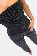 Black strapless glitter jumpsuit close-up: ruched waist seams and patch pockets