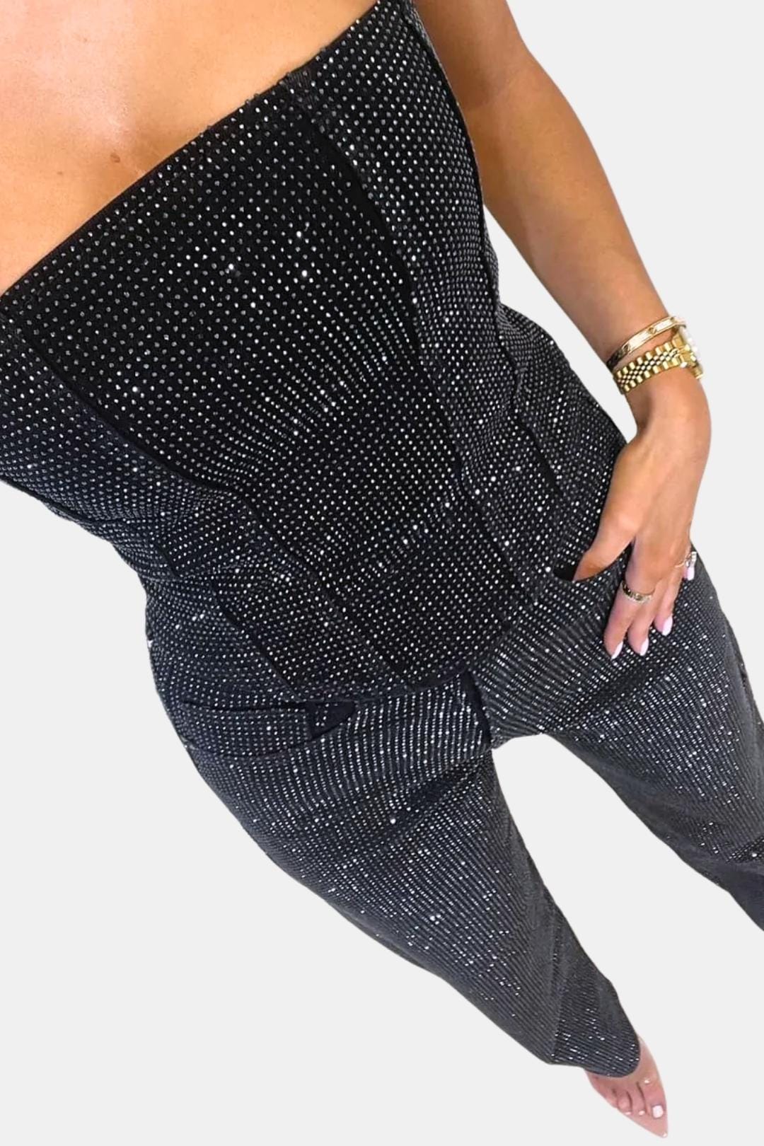 Black strapless glitter jumpsuit close-up: ruched waist seams and patch pockets