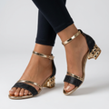 Open-toe sandals with gold straps, black glitter toe strap, and low block heels
