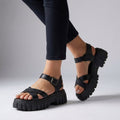 Black platform sandals with adjustable buckle straps and thick lug sole