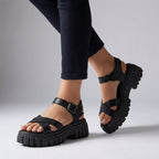 Black platform sandals with adjustable buckle straps and thick lug sole