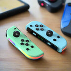 Mint green and light blue Nintendo Switch RGB LED joy-con controllers on a wooden table.