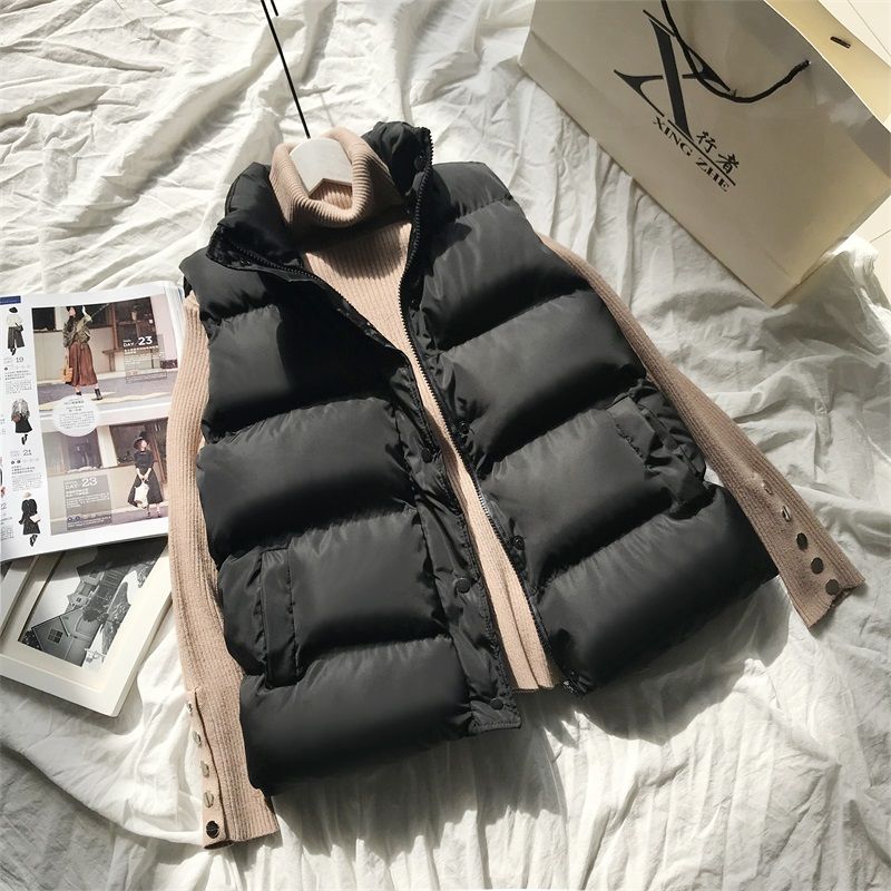 Black quilted puffer bodywarmer with full front zipper and stand collar, ribbed knit cuff