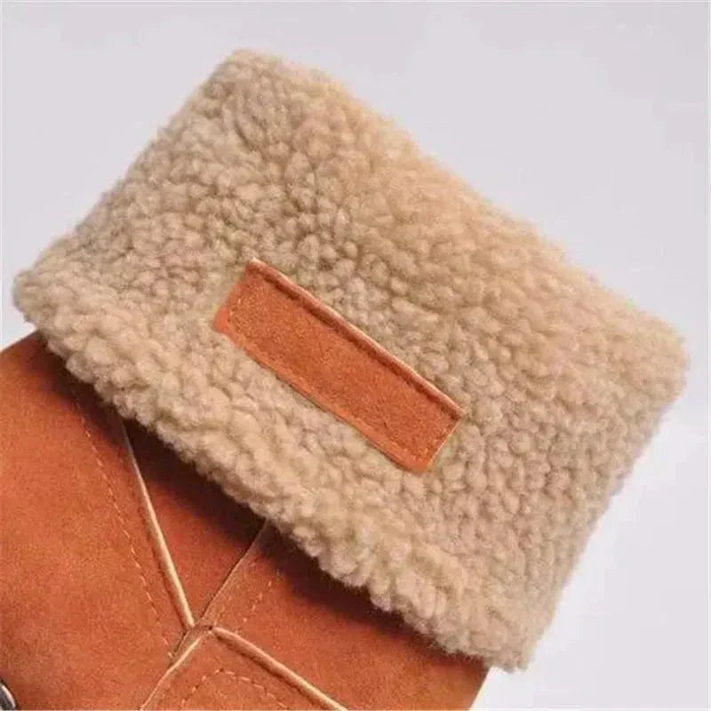 Tan suede winter boot with beige sherpa cuff and brown trim patch