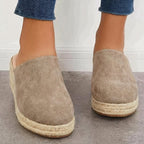 Black closed-toe espadrille wedge mules with slip-on fit and braided jute platform.