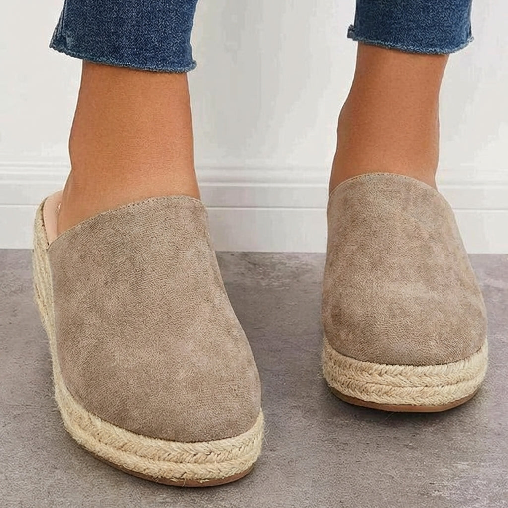 Black closed-toe espadrille wedge mules with slip-on fit and braided jute platform.
