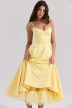 Yellow corset-style sleeveless midi dress with sweetheart neckline and layered tulle hem.
