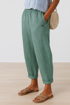 Light green women's pants with elastic waist, side seam pockets, button detail, ankle cuffs