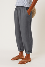 Grey women's pants with elastic waistband, side seam pockets, button detail, ankle cuffs