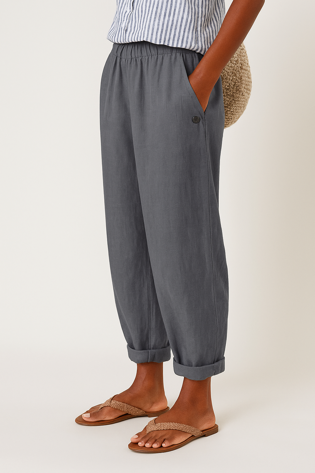 Grey women's pants with elastic waistband, side seam pockets, button detail, ankle cuffs