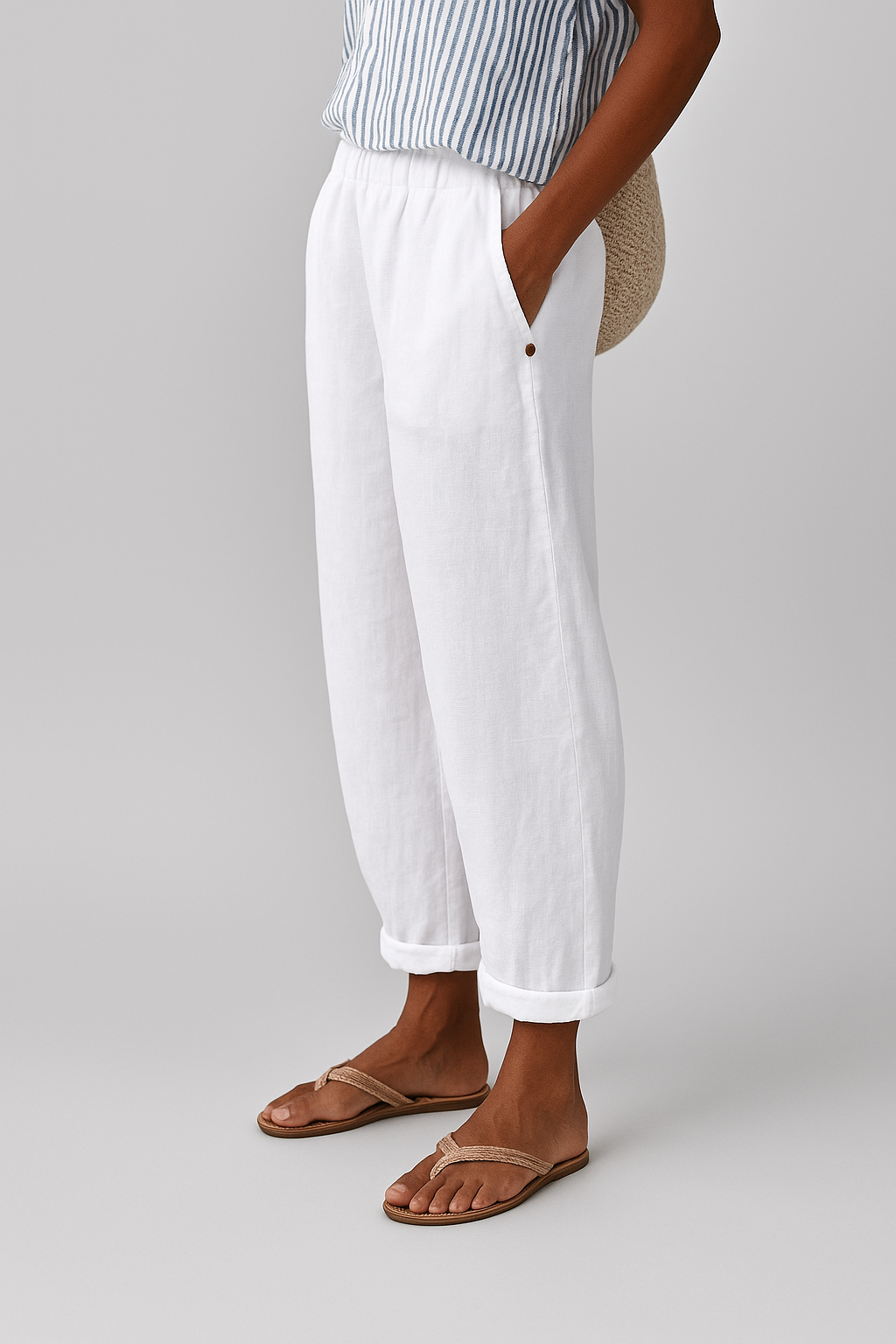 White women's pants with elastic waistband, side seam pockets, button detail, ankle cuffs