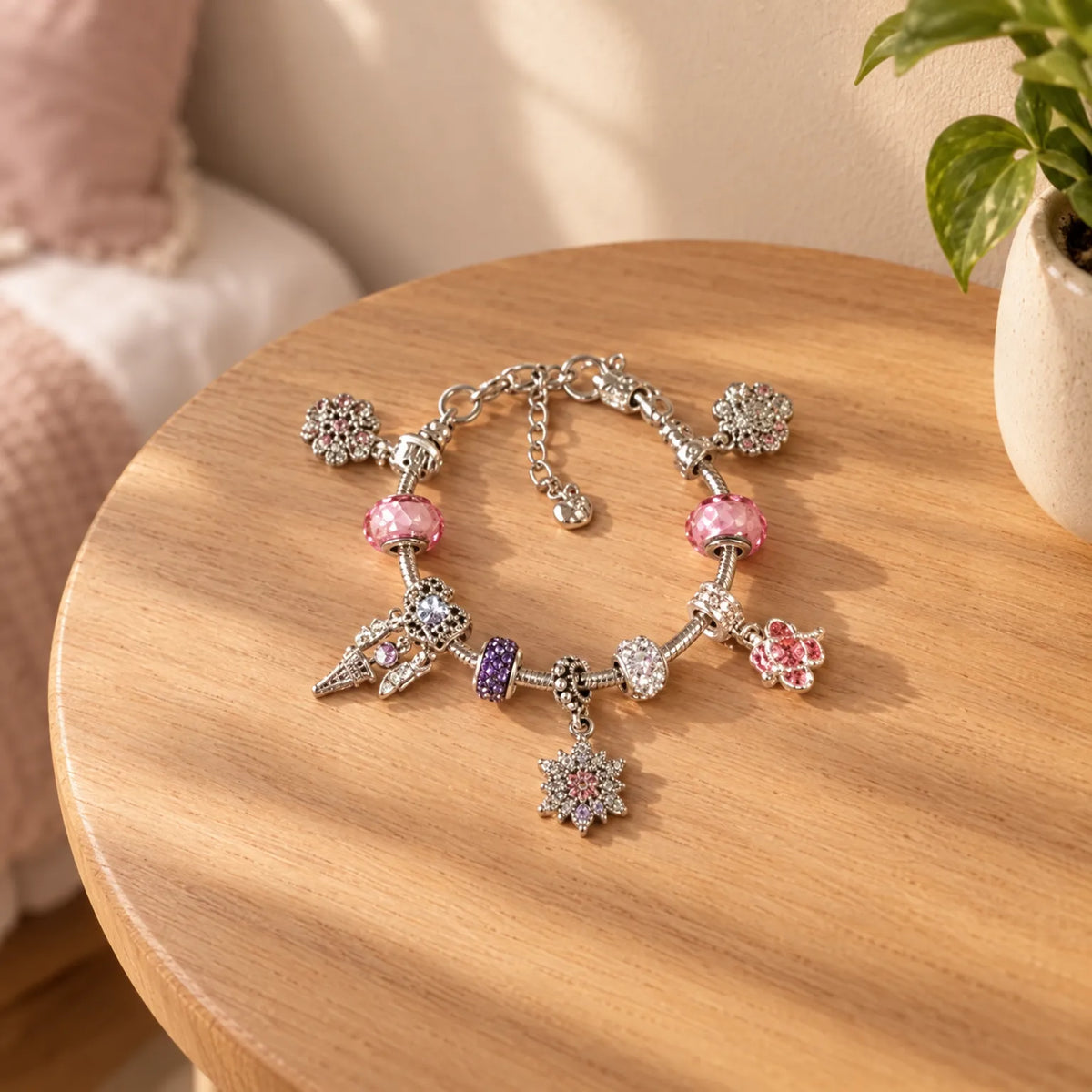 Silver charm bracelet with pink bead accents and star, heart, and flower charms