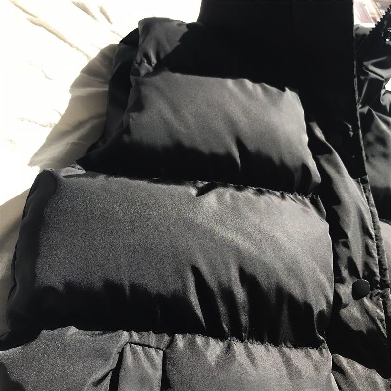Dark gray quilted puffer bodywarmer with high neck and front zipper, padded shoulders