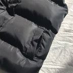 Dark gray puffer bodywarmer close-up with stitched paneling and gathered waist hem
