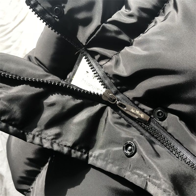 Black puffer bodywarmer detail: metal zipper with snaps, stitched stand collar