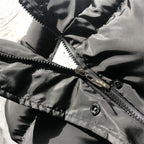 Black puffer bodywarmer detail: metal zipper with snaps, stitched stand collar