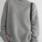 Gray cashmere turtleneck sweater close-up with ribbed hem and long sleeves.