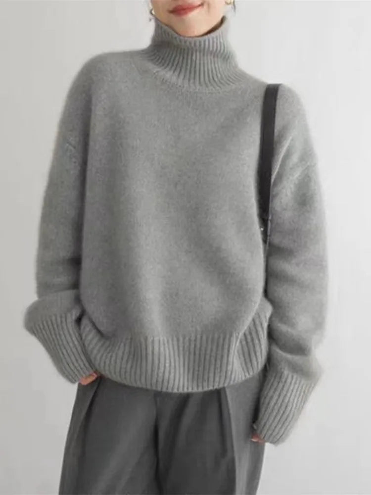 Women's gray turtleneck knit sweater with ribbed cuffs and relaxed long sleeves