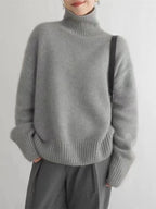 Women's gray turtleneck knit sweater with ribbed cuffs and relaxed long sleeves