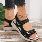 Women’s black sandals with adjustable straps, open toe, and cushioned platform sole