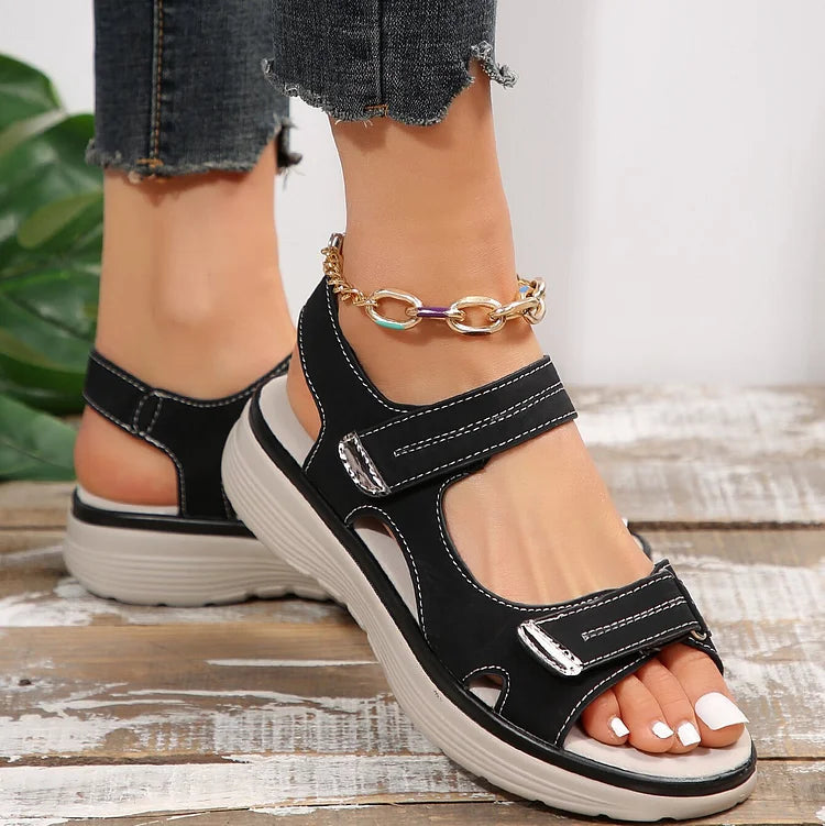 Women’s black sandals with adjustable straps, open toe, and cushioned platform sole