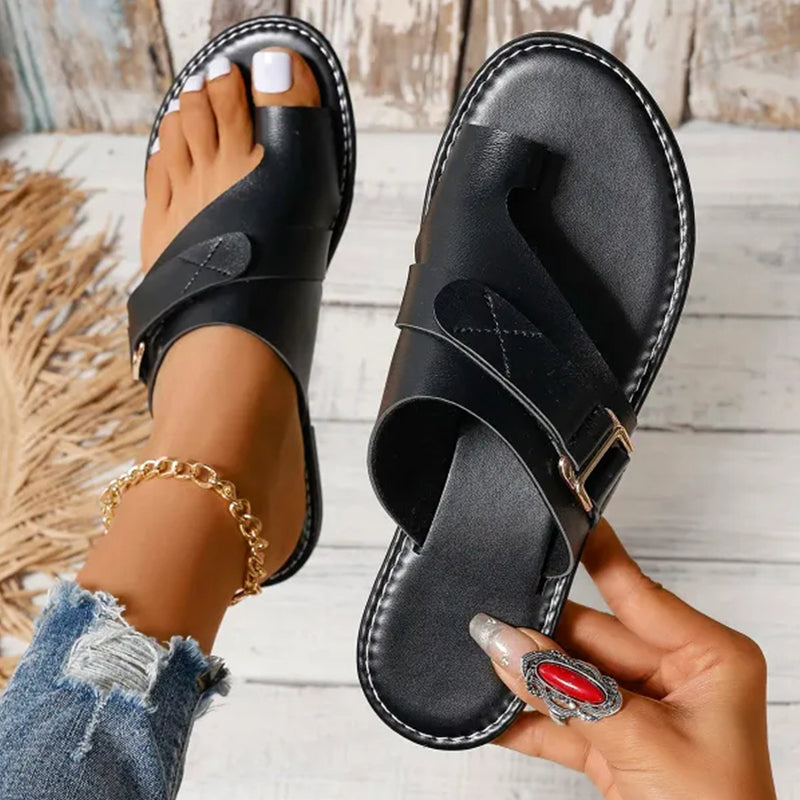 Women’s black slide sandals with adjustable strap and metal buckle, open toe