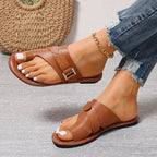 Women’s brown open-toe sandals with two straps and metal buckle on flat sole