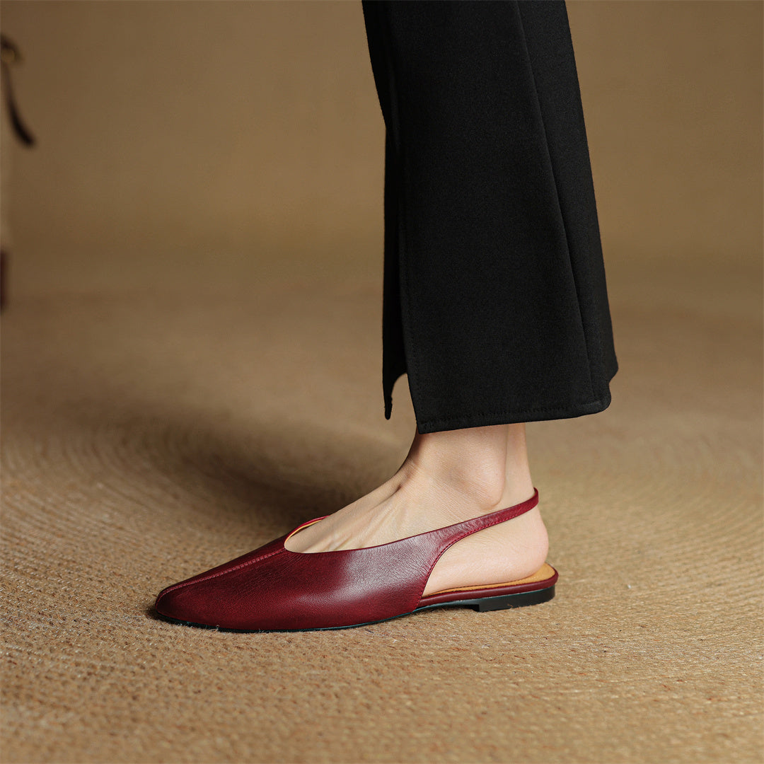 Wine red leather slingback flats on foot with pointed toe and low profile sole