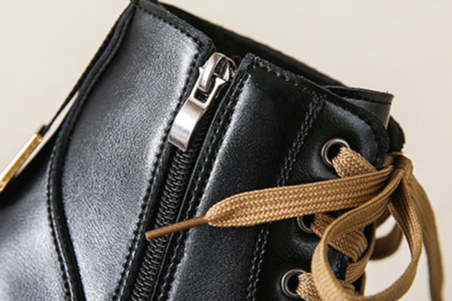 Women's black side-zip lace-up boots with silver zipper hardware and tan laces