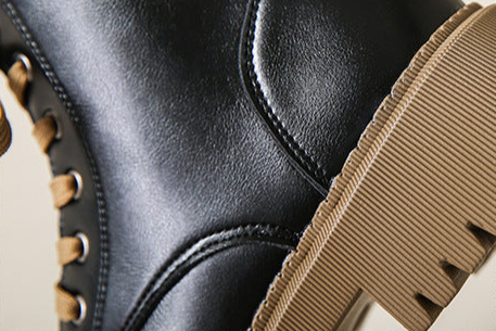 Women's black boot with side-zip detail and textured tread platform sole close-up