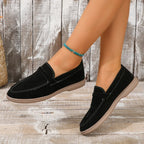 Black suede slip-on loafers with moc-toe stitching and white rubber sole