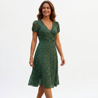 Green A-line midi dress with V-neck and short puff sleeves, textured pattern.