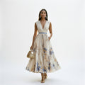 White maxi dress with V-neck and sleeveless shoulders, gathered waist, blue floral print